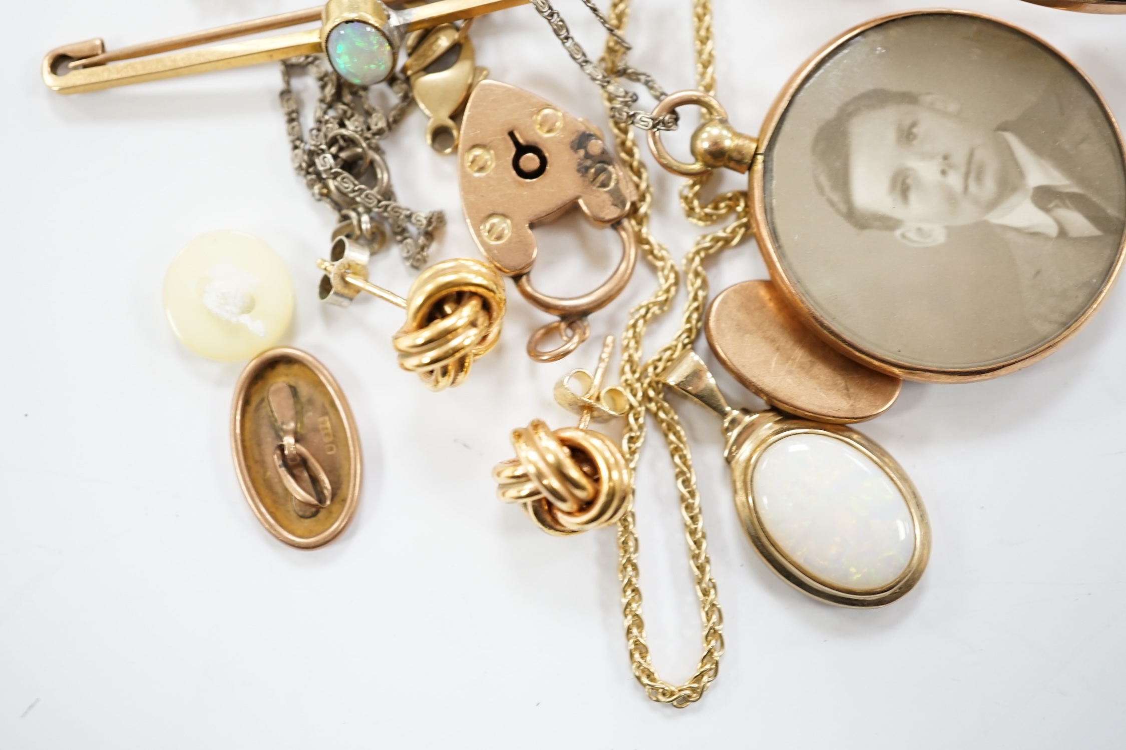 A lady's yellow metal manual wind wrist watch, on a 9ct expanding bracelet, a modern 9ct gold and white opal set pendant, on a 375 chain and other minor jewellery including a pair of 9ct gold knot earrings.